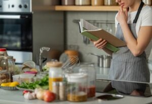 Une cuisine moderne avec un plan de travail encombré montrant des ustensiles, des ingrédients et des contenants, illustrant les erreurs courantes en batch cooking.
